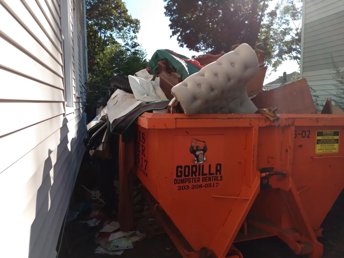 Overloaded dumpster rental with mattress in Connecticut